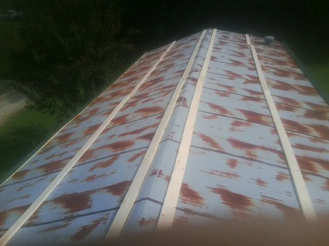 Rusted metal roof panels with new wood purlins before replacement — Storm Damage Roof Repair in Muldoon by Roofing Brothers