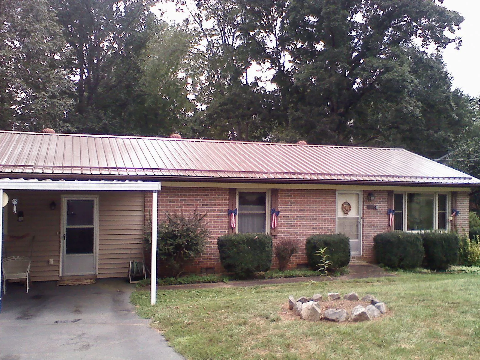 Bronze metal roof and carport on a brick ranch home — Roof Repair work by our crew in Muldoon